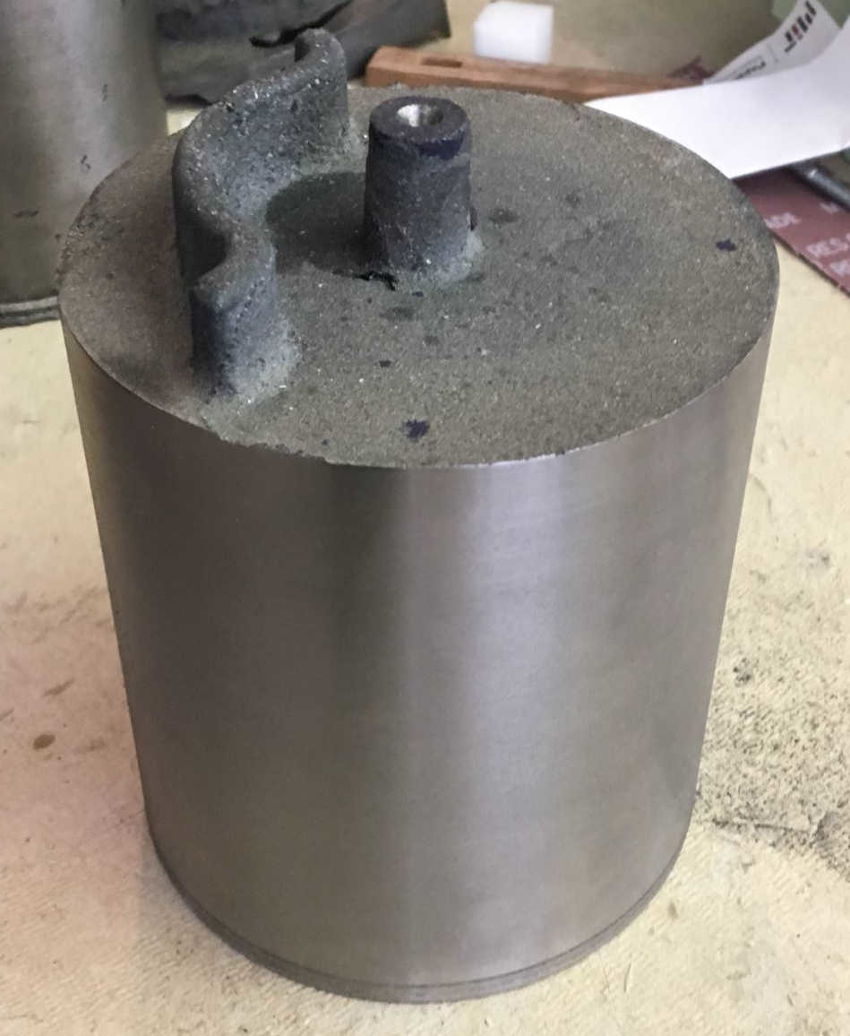 Piston after initial machining of the OD, but still oversize of its finished dimension. This machined OD served as a reference to clean up the bottom surface of the piston skirt so that it could provide a flat and square datum for future operations.